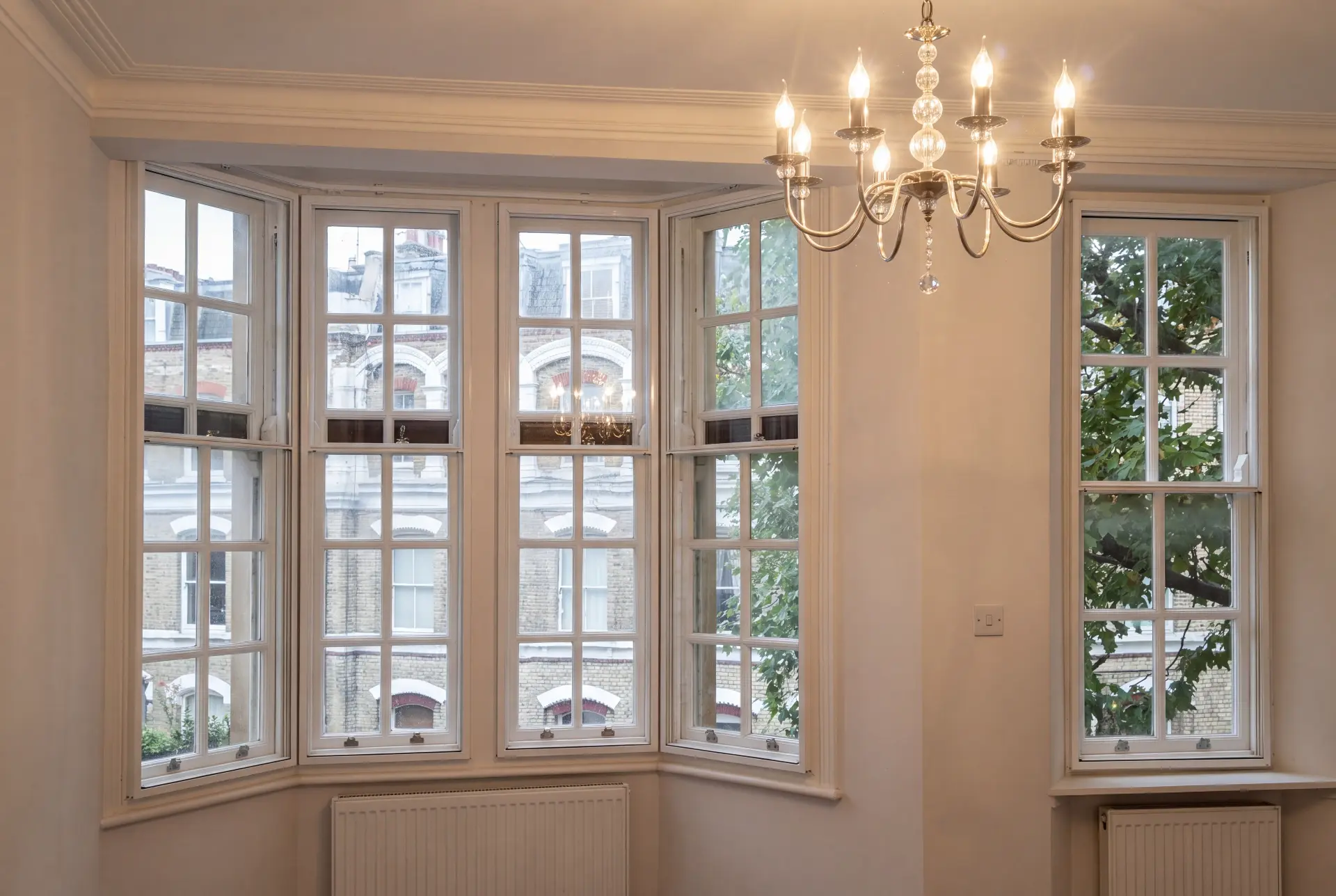 Chandelier bay reception — secondary glazing in Islington, London Georgian bar bay window with secondary glazing in a period reception room lit by a chandelier
