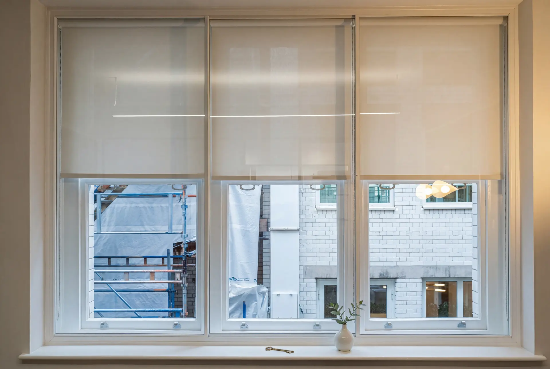Lift-out with blinds — secondary glazing in Farringdon, London Three lift-out secondary glazing panels behind cream roller blinds in a city office