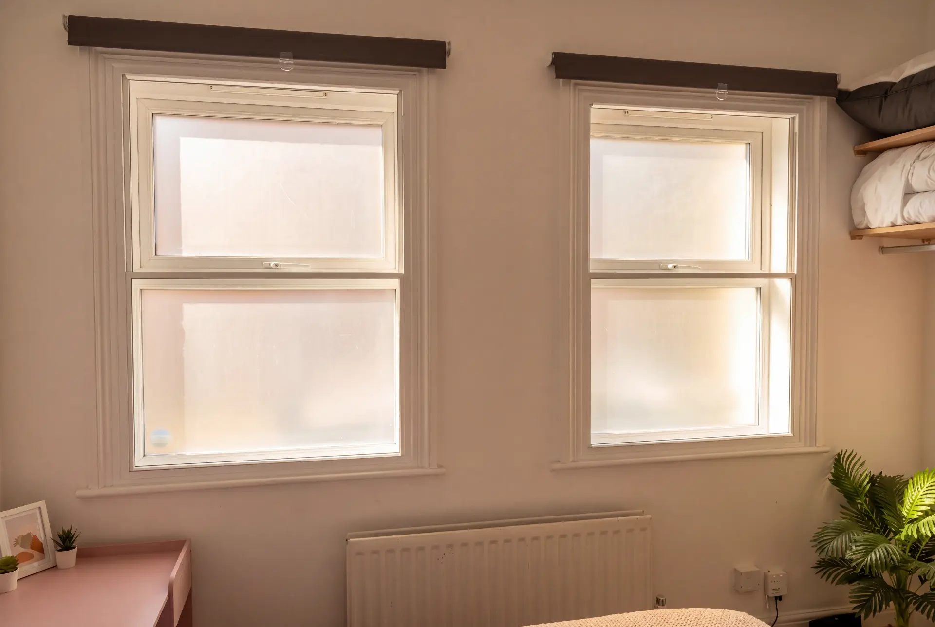 Obscured privacy sashes — secondary glazing in Peckham, London Two secondary glazed sash windows with obscured glass in a warm bedroom