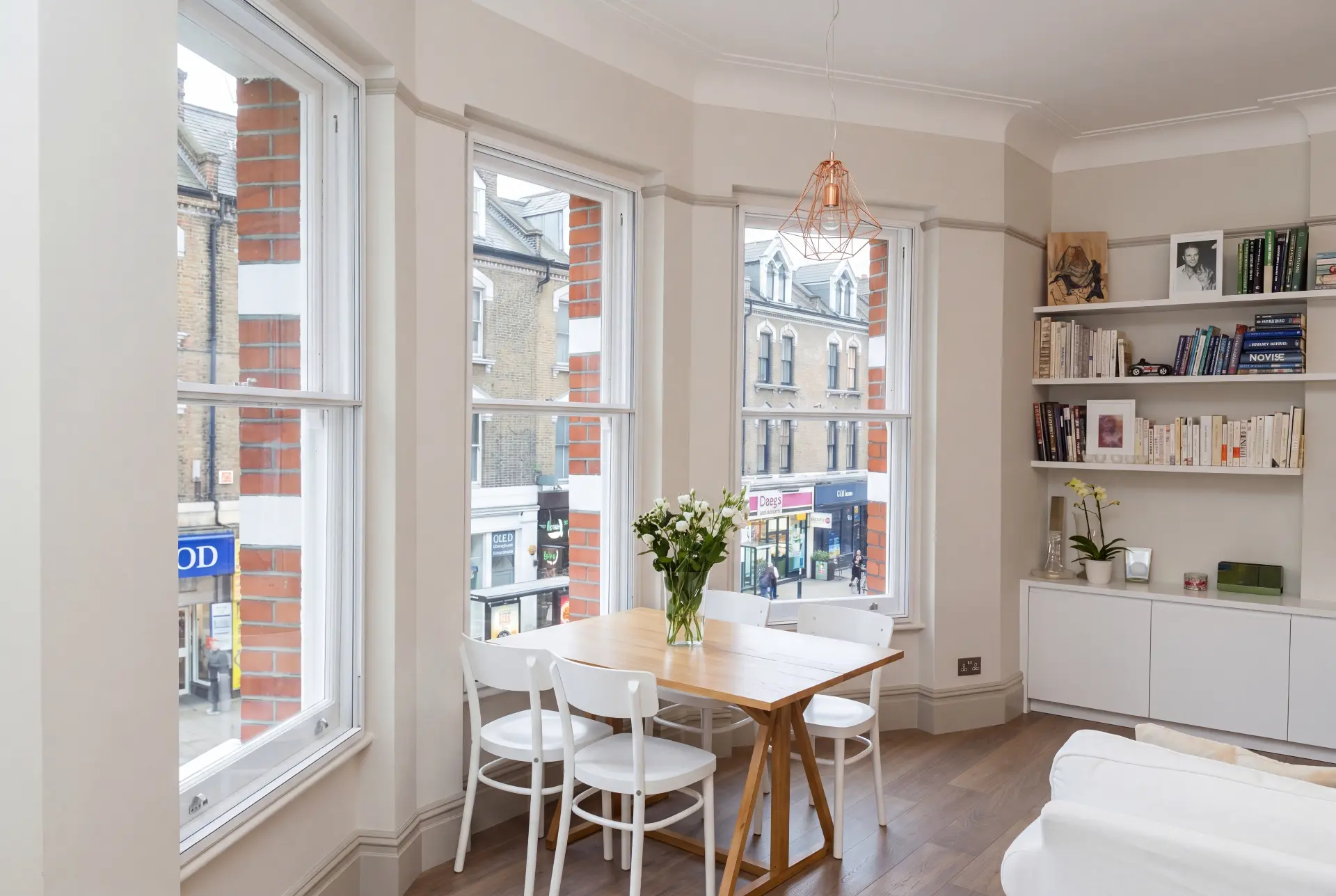 High street bay dining — secondary glazing in Hackney, London Dining area in a curved bay with three secondary glazed sash windows above a London high street
