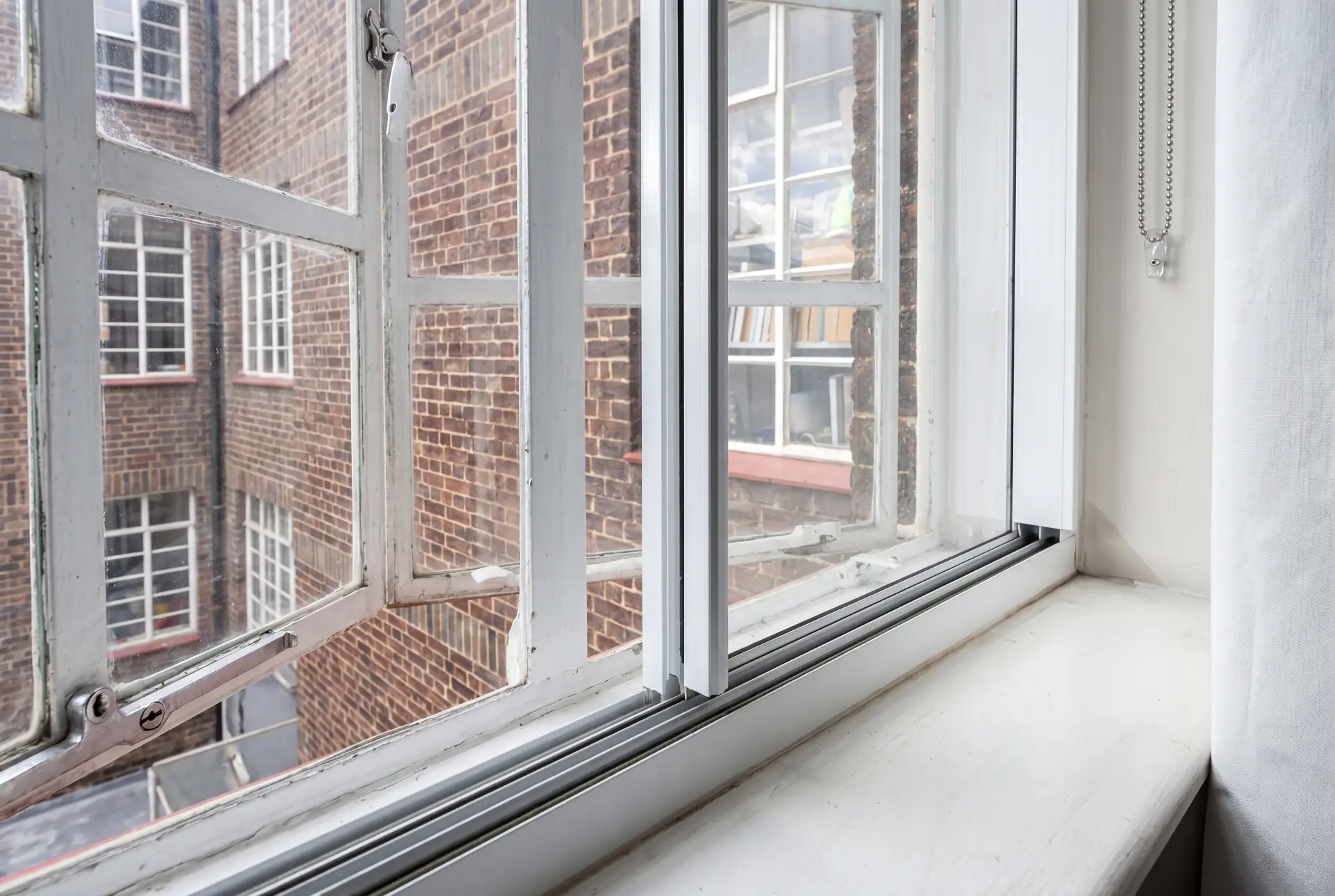 Slim track detail — secondary glazing in Clerkenwell, London Close-up detail of a slim secondary glazing track and interlock fitted to an original steel window
