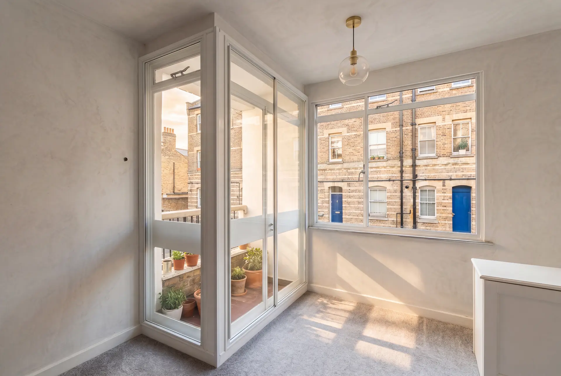 Corner balcony room — secondary glazing in Kennington, London Corner room with secondary glazed balcony doors and a wide slider facing a brick terrace
