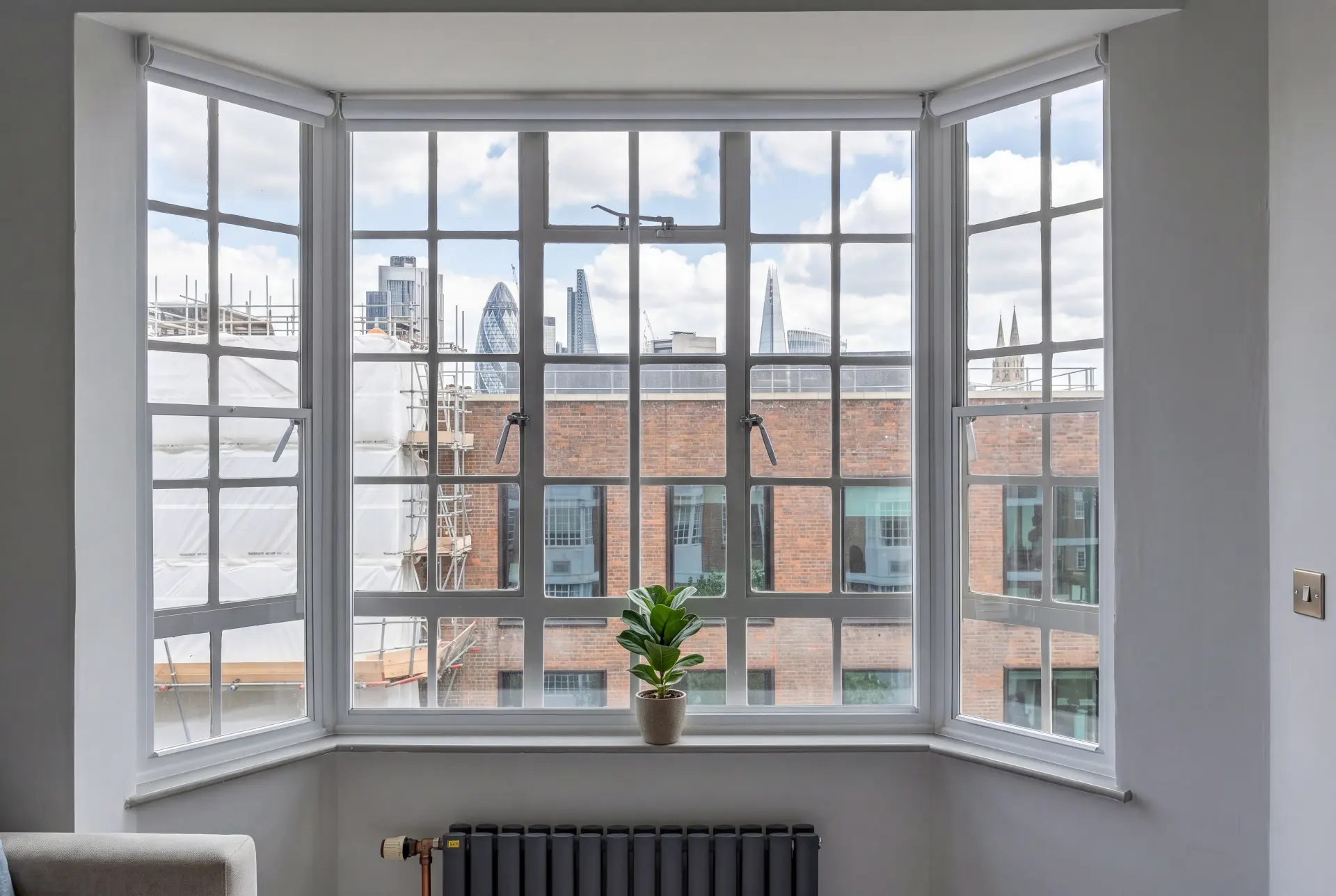 Crittall bay, City view — secondary glazing in Shoreditch, London Crittall-style bay window with secondary glazing framing the City of London skyline