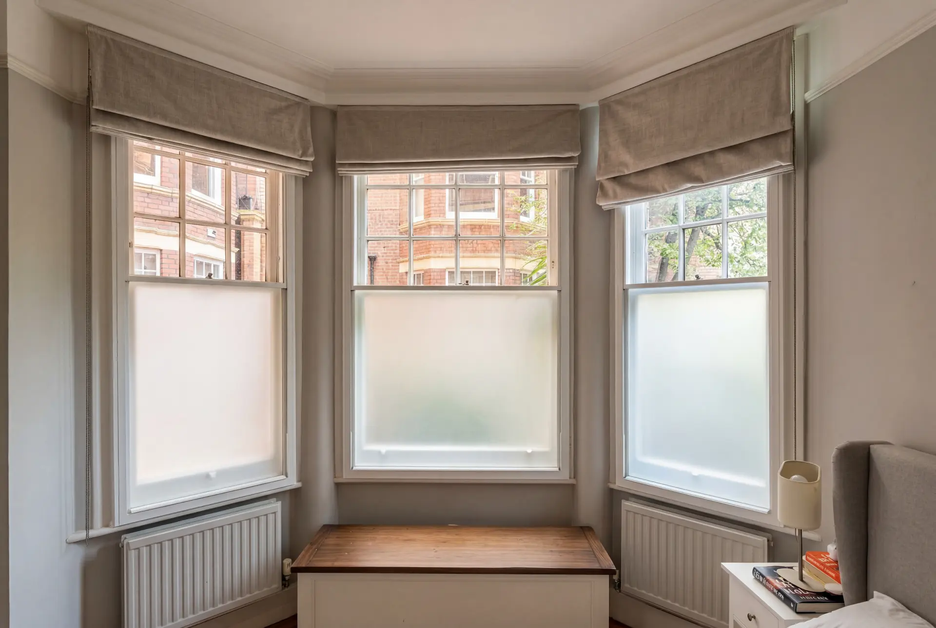 Mansion block bay bedroom — secondary glazing in South Kensington, London Bedroom bay with three secondary glazed sash windows and privacy blinds facing a red brick mansion block