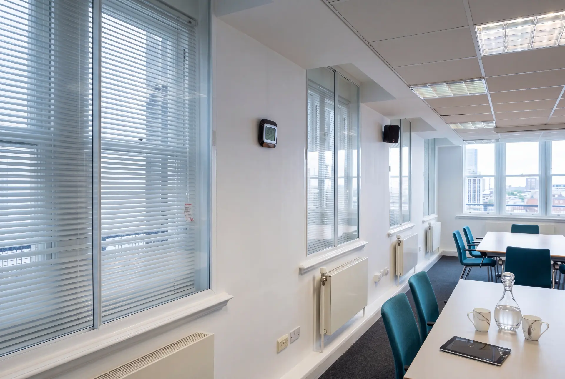 Integral blind meeting room — secondary glazing in Canary Wharf, London Meeting room with secondary glazing behind integral venetian blinds facing the London skyline