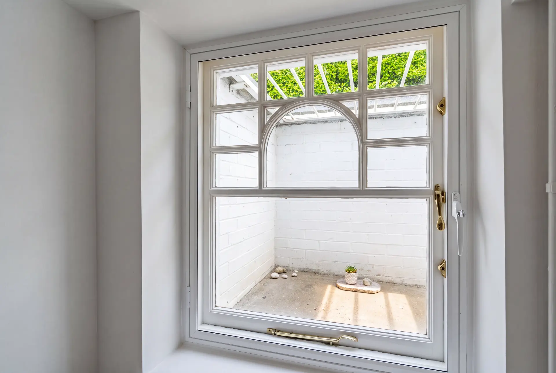 Arched casement — secondary glazing in Hampstead, London Cottage-style arched casement window with secondary glazing and brass furniture