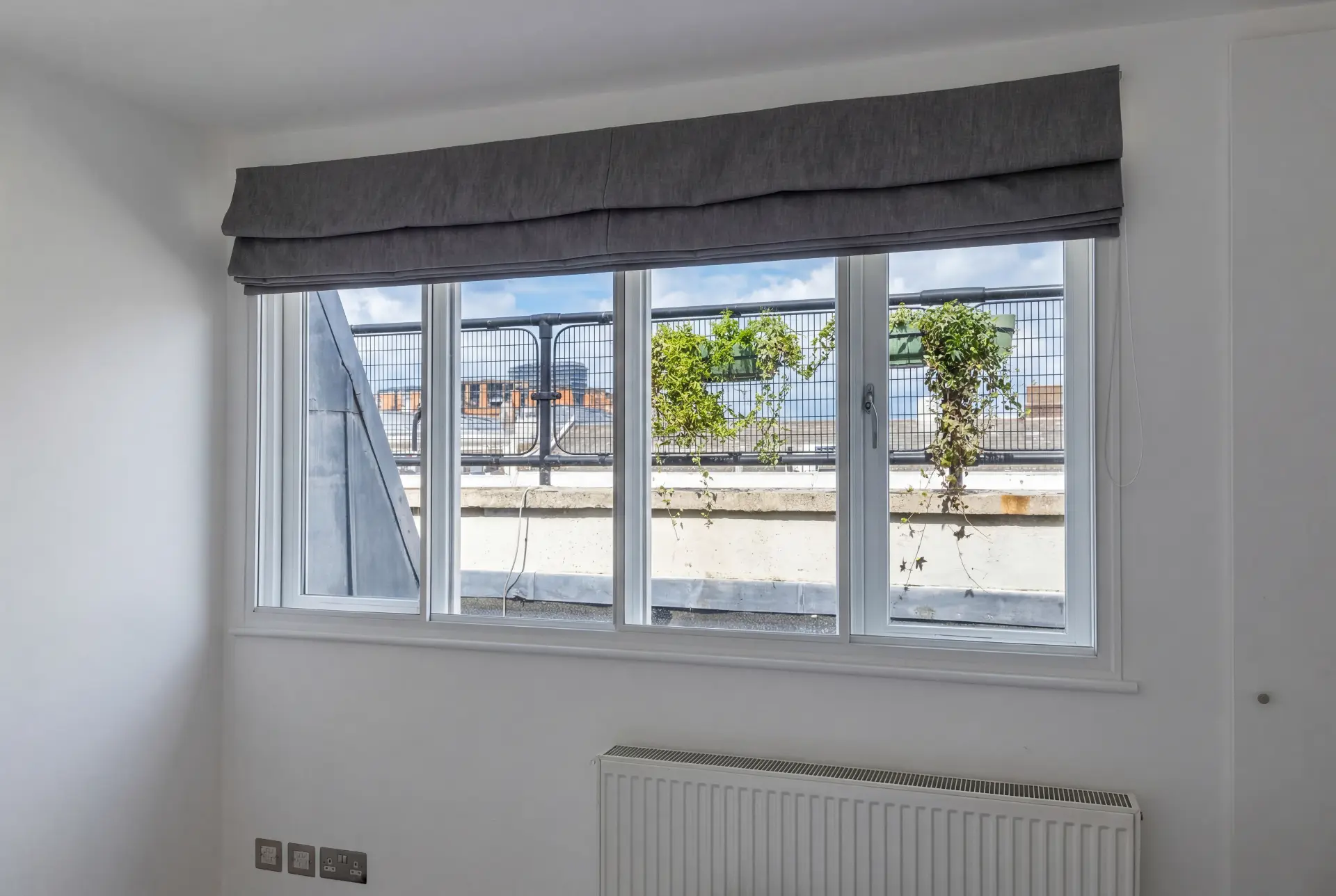 Penthouse slider run — secondary glazing in Wapping, London Wide secondary glazed slider run in a penthouse bedroom overlooking a rooftop parapet