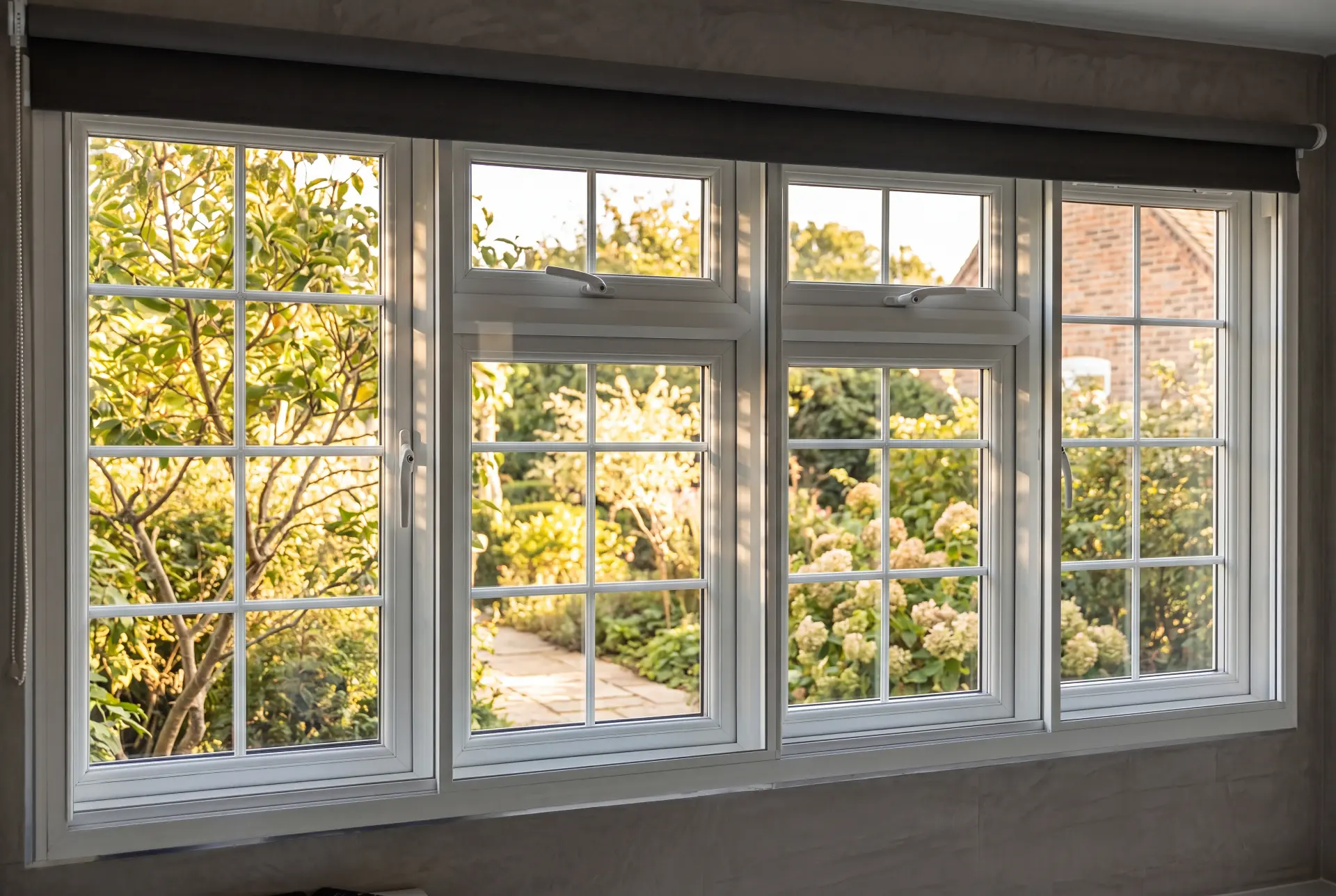 Garden casement run — secondary glazing in Dulwich, London Four-panel Georgian bar secondary glazing across a wide window facing a sunlit garden