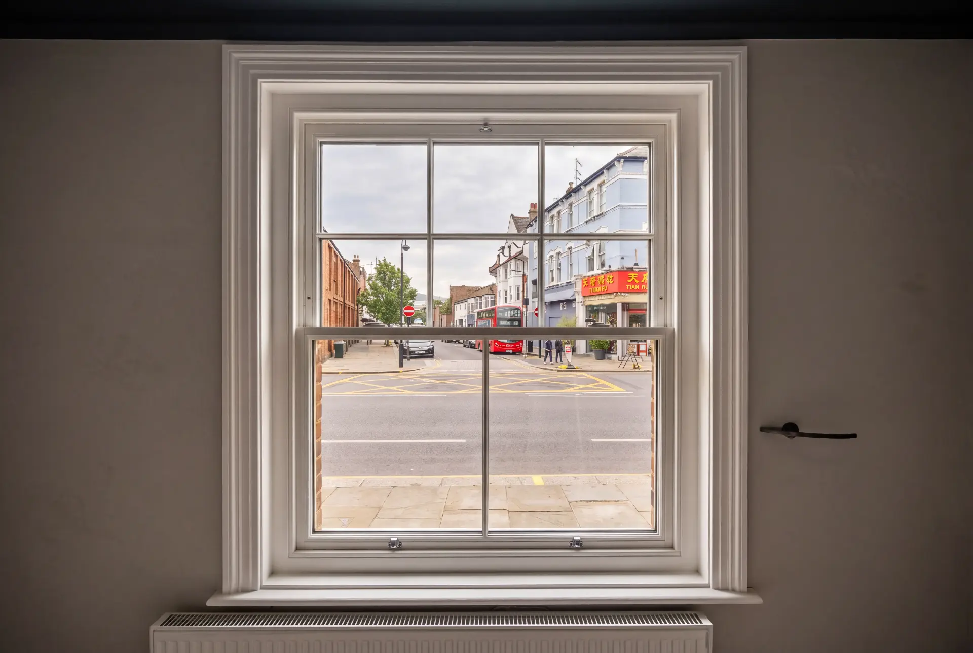High street sash — secondary glazing in Muswell Hill, London Single Georgian bar sash window with secondary glazing overlooking a London high street and bus route
