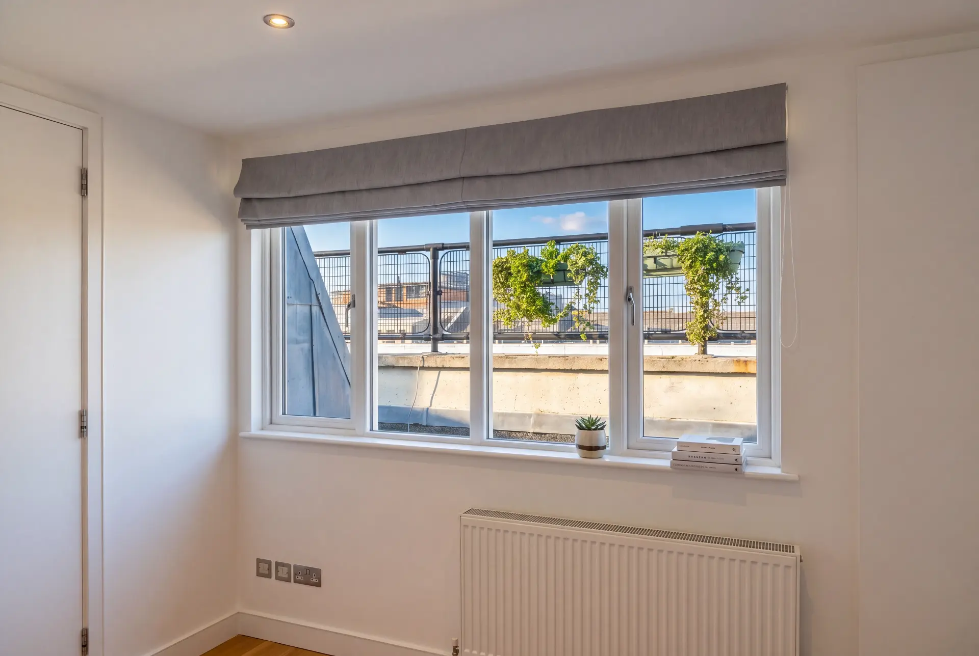 Roof terrace slider — secondary glazing in Shoreditch, London Four-panel secondary glazed slider facing a planted roof terrace behind a grey roman blind
