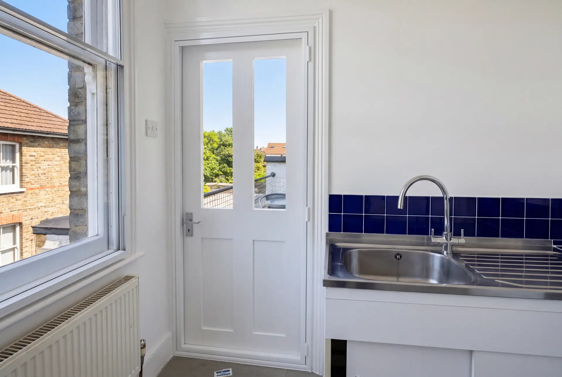 Kitchen terrace door — secondary glazing in Crystal Palace, London Secondary glazed terrace door and window in a bright kitchen with blue tiled splashback