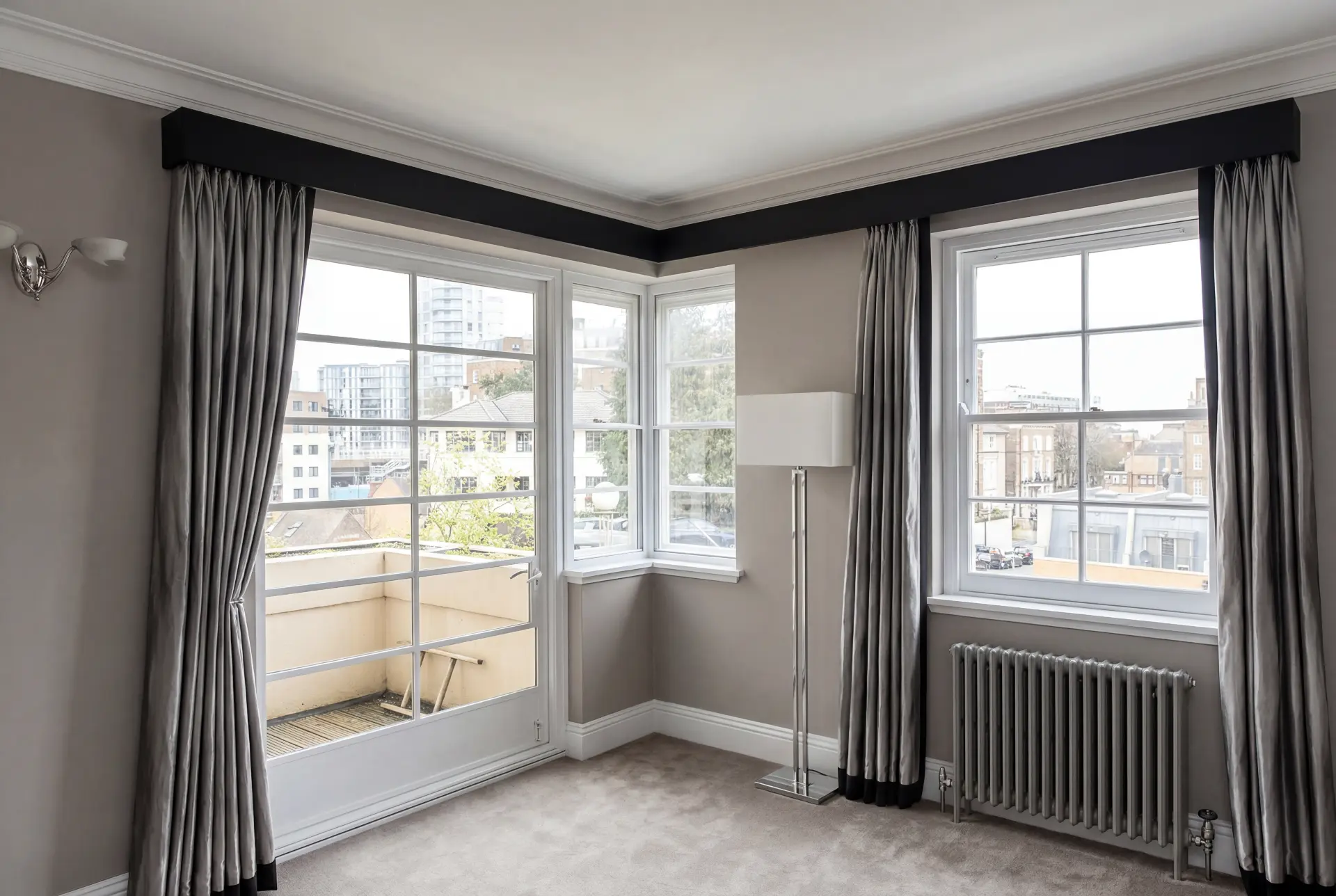 Balcony door and bay — secondary glazing in Battersea, London Reception room with secondary glazing on a balcony door and angled bay windows behind silk curtains