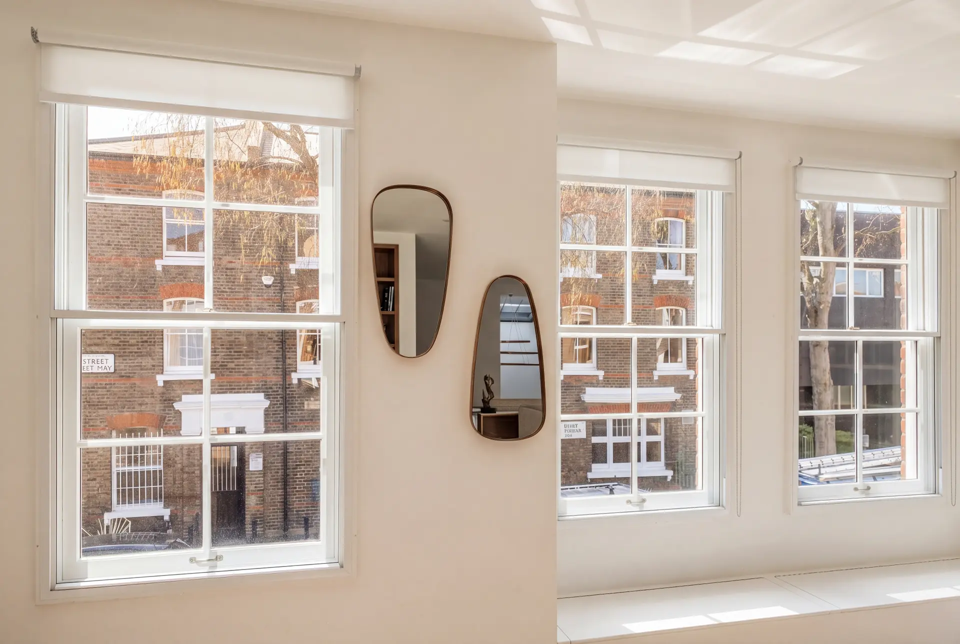 Corner sash trio — secondary glazing in Islington, London Corner room with three secondary glazed sash windows facing a Georgian brick terrace