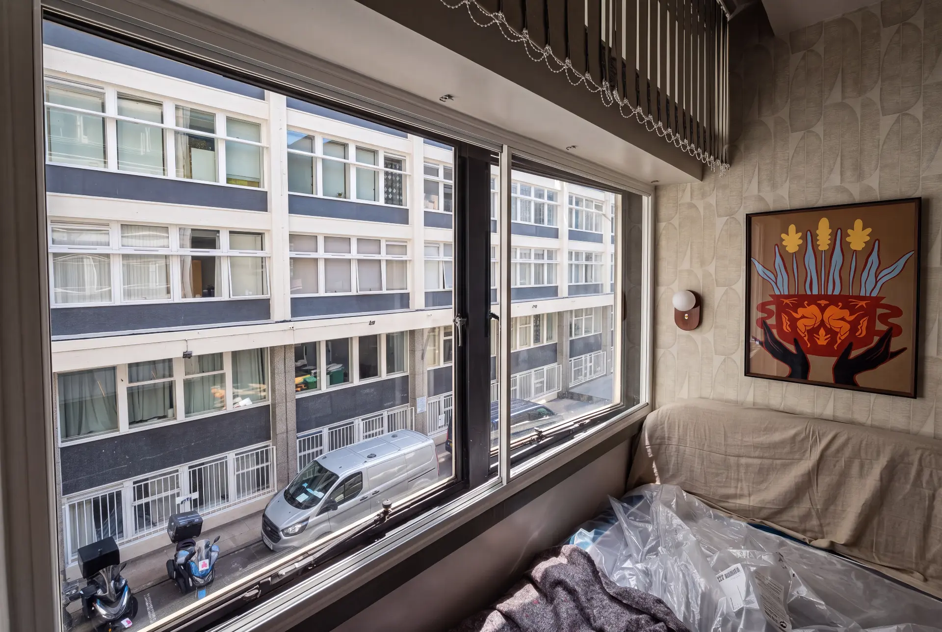 Wide street-facing slider — secondary glazing in Fitzrovia, London Wide horizontal sliding secondary glazing over a busy London street with parked vehicles