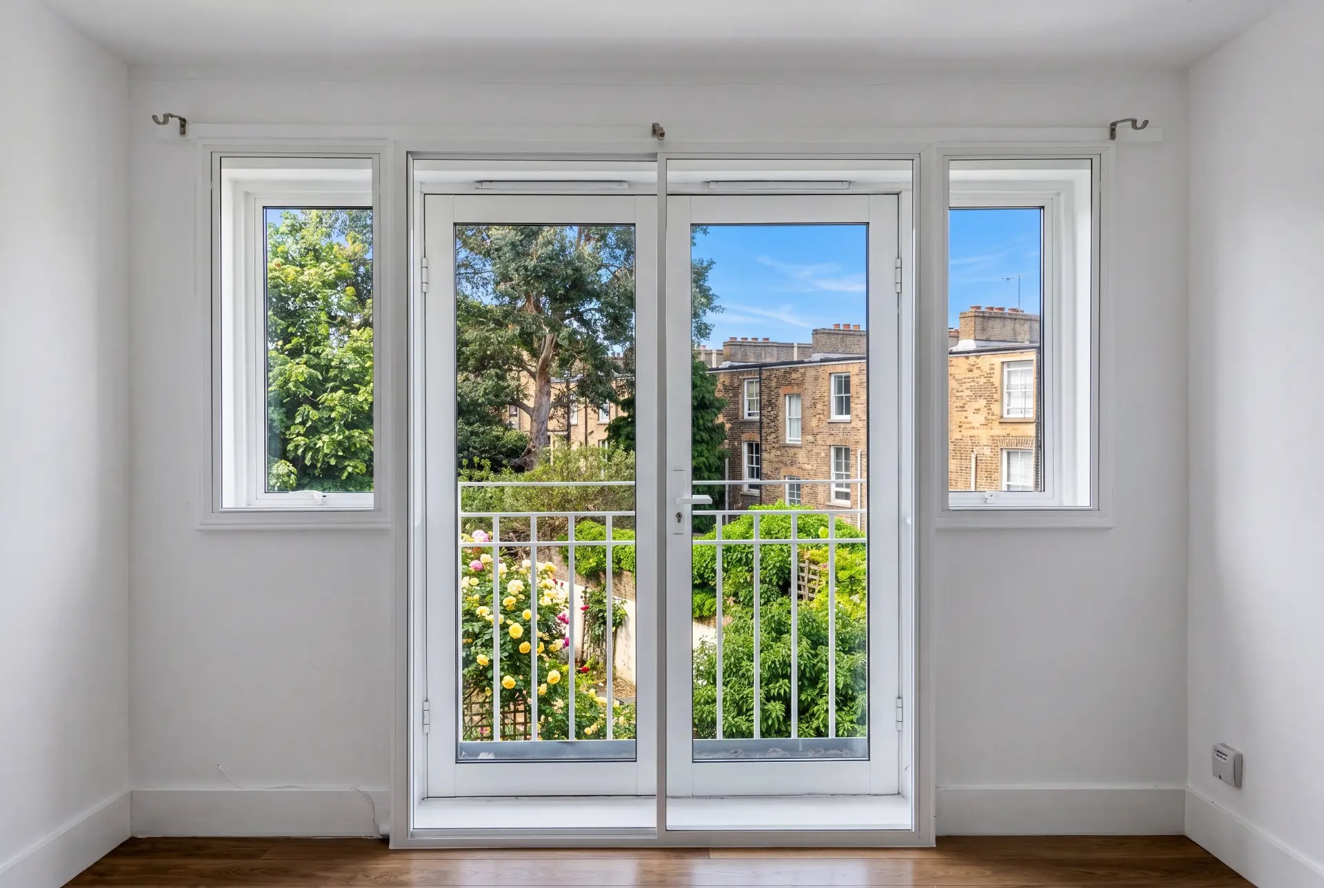 Garden French doors — secondary glazing in Barnsbury, London Secondary glazed French doors with flanking casements looking onto a rose garden and brick terraces