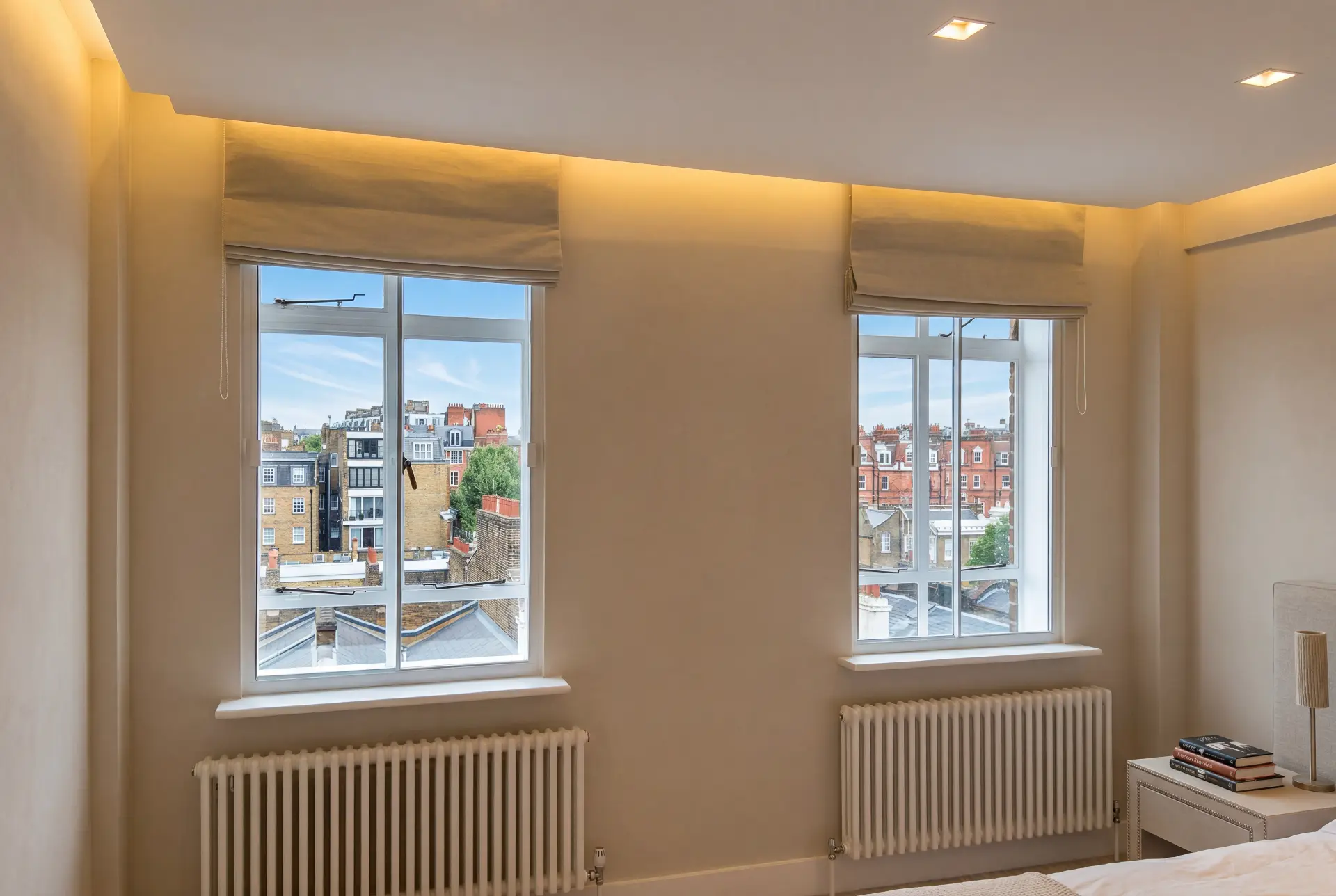 Warm bedroom pair — secondary glazing in Chelsea, London Bedroom with two secondary glazed windows and roman blinds overlooking London brick terraces