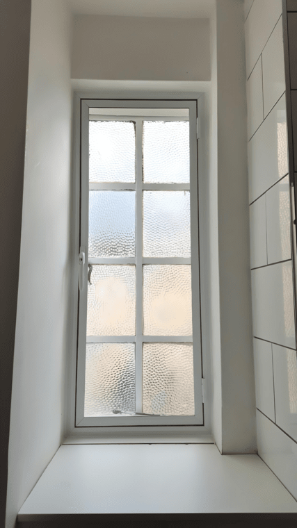 Bathroom window with frosted acoustic secondary glazing for privacy and noise reduction