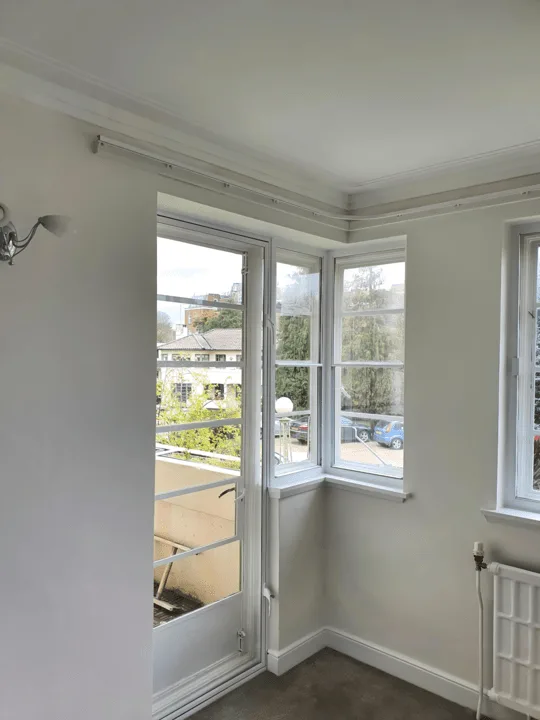 Door secondary glazing installation in corner room with multiple windows