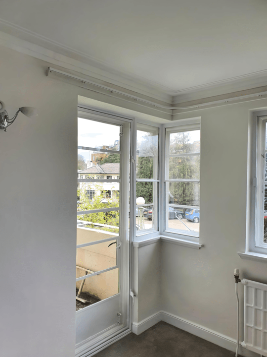Door secondary glazing installation in corner room with multiple windows